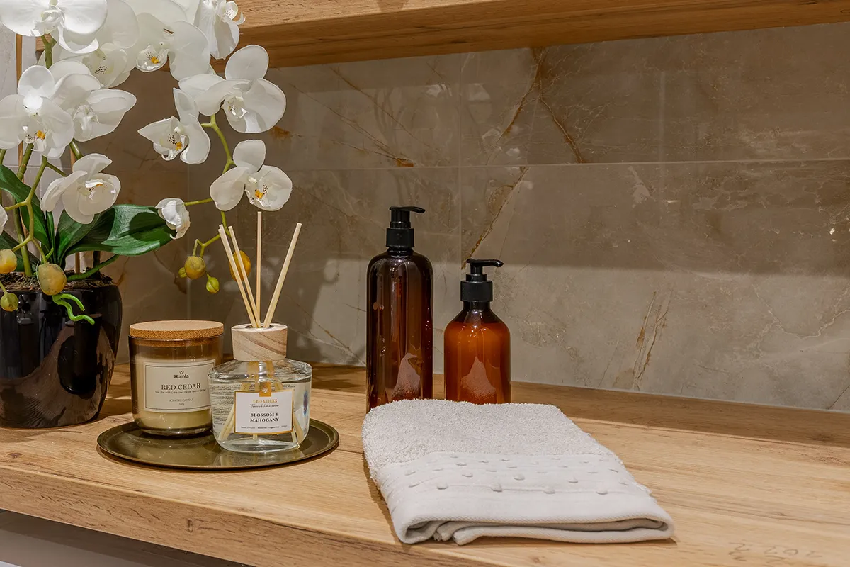 Zbliżenie na akcesoria łazienkowe w łazience z marmurowymi kaflami - fotografia nieruchomosći Katarzyna Sołtysiak