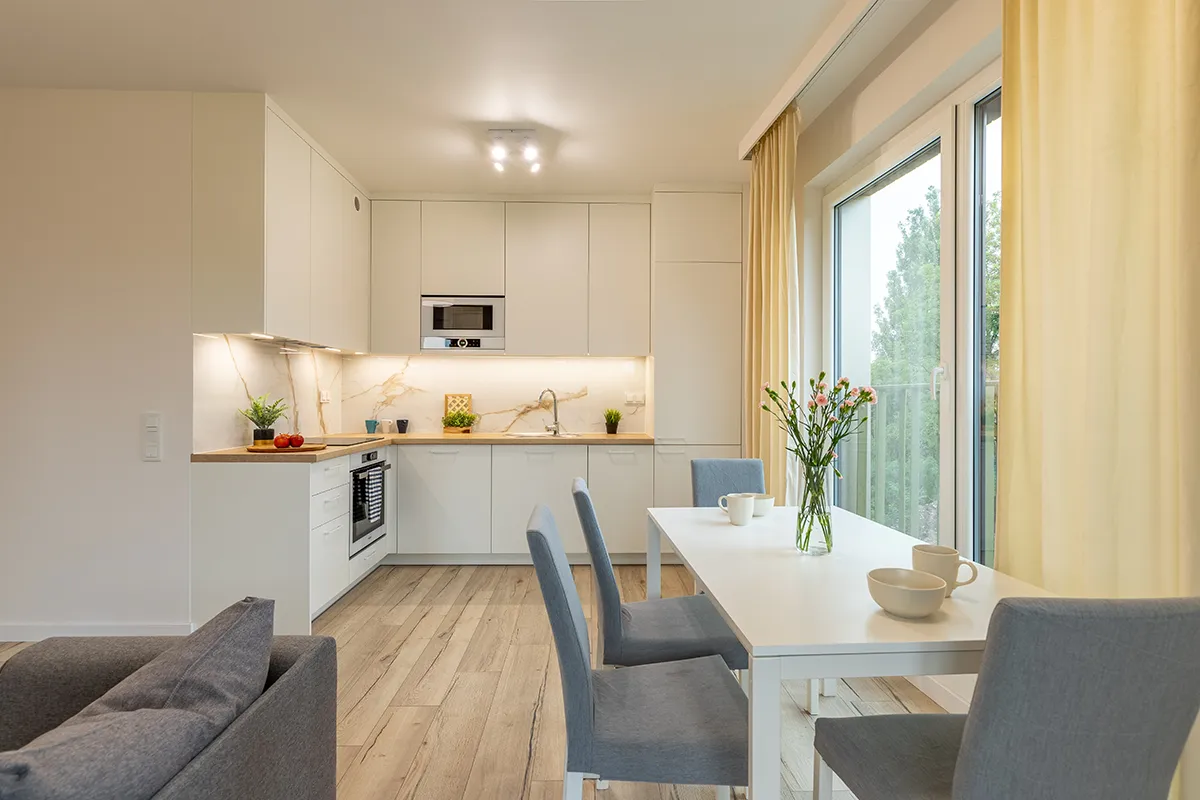 Nowoczesny salon z aneksem kuchennym w jasnych barwach - zdjęcia dla agencji nieruchomości Łódź