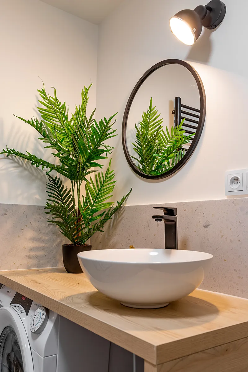 Łazienka z reflektorem oraz okrągłm lustrem, pralka pod umywalką - Fotografia Łódź