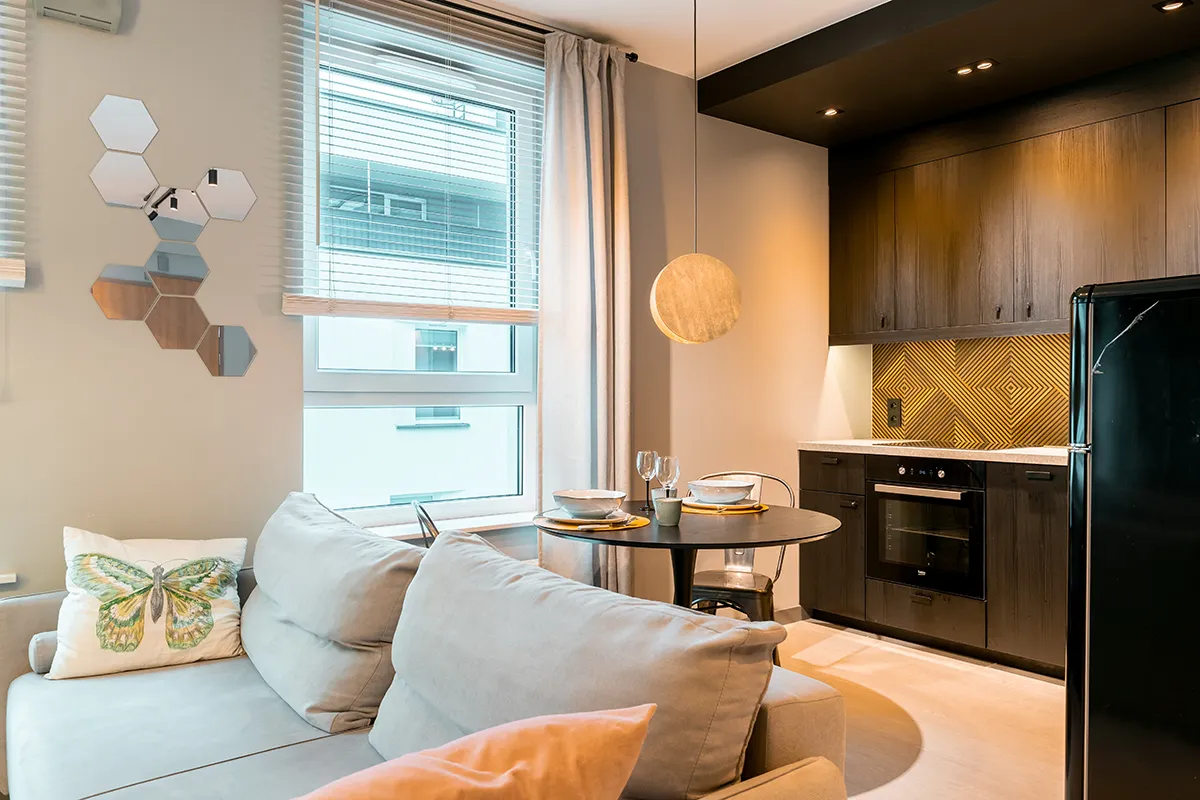 Salon w industrialnym stylu z aneksem kuchennym oraz czarną lodówką - zdjęcia pod booking