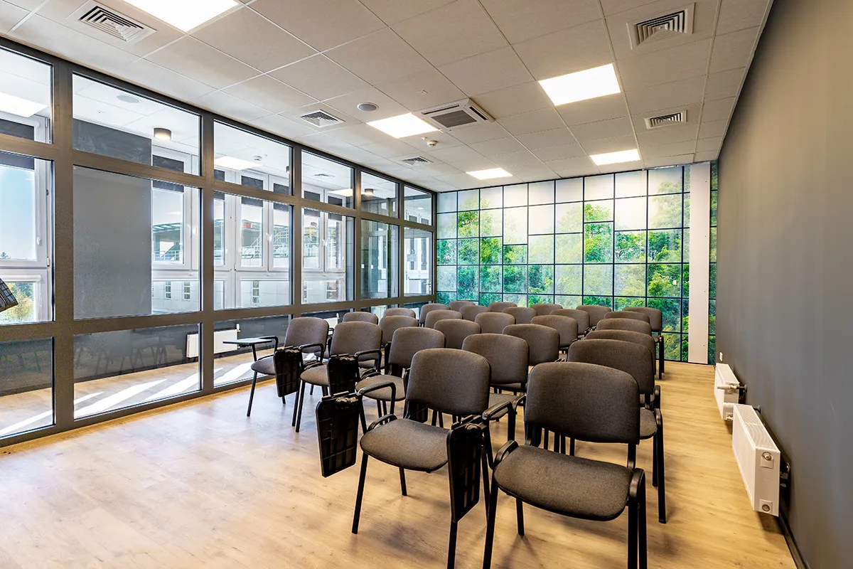 Sala wykładowa z rzędami krzeseł i przeszkolną ścianą - szybkie i profesjonalne zdjęcia wnętrz